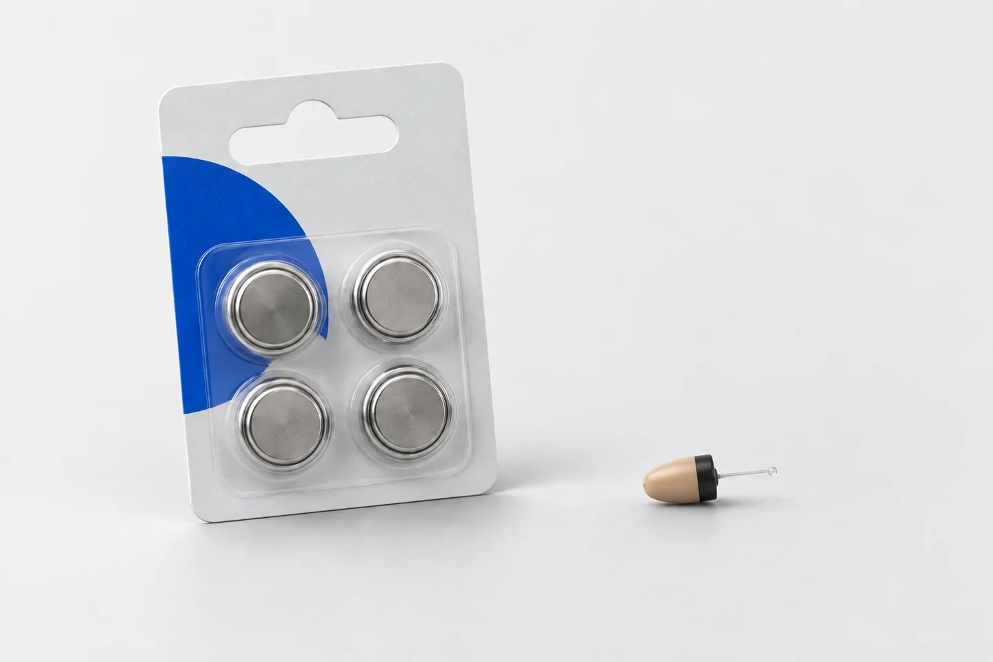 Editorial illustration of button cell batteries beside a miniature beige earpiece.