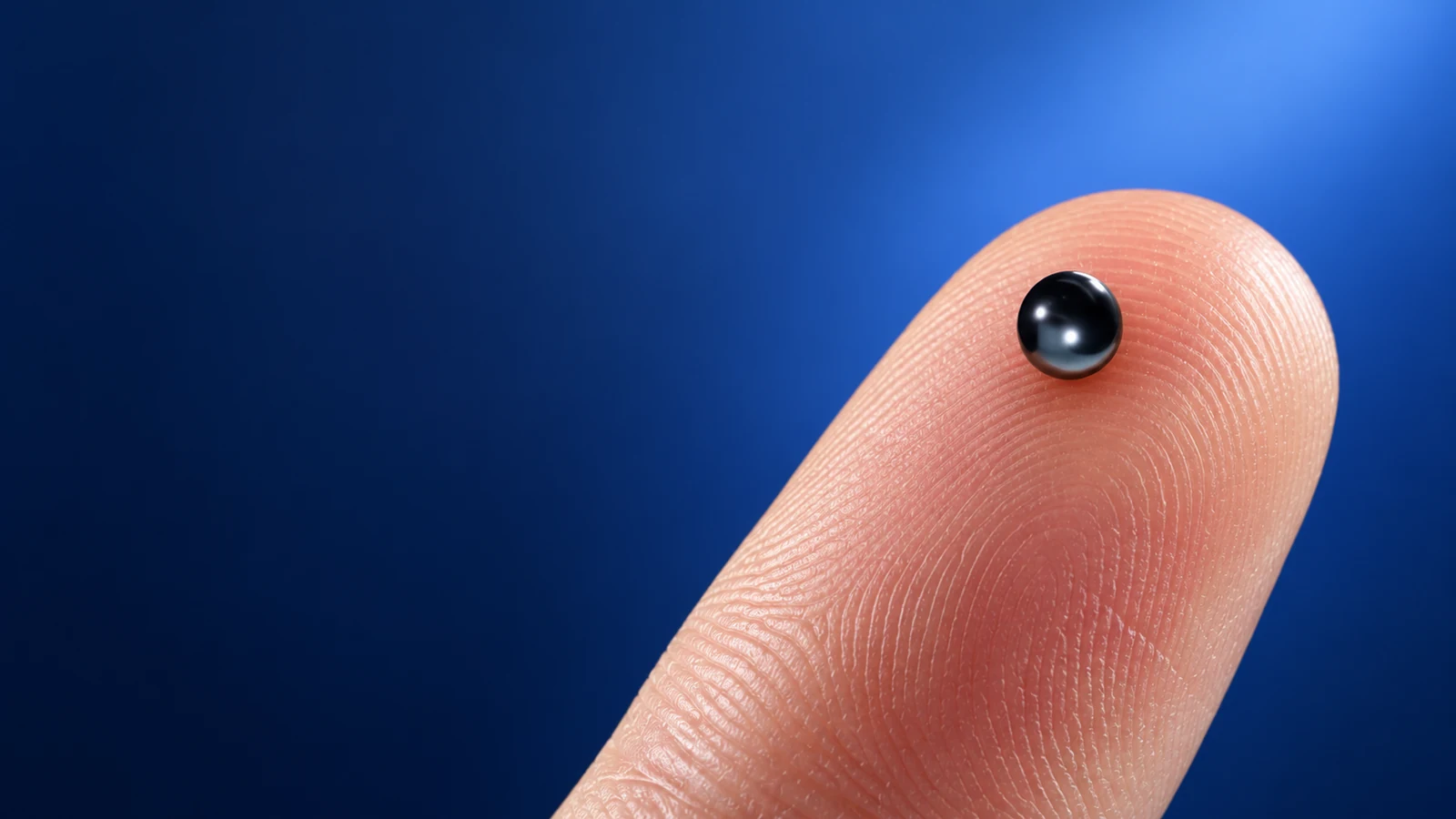 Macro view of a magnetic Nano earpiece on a fingertip